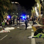 Photograph of the street in Nice where pedestrians were killed an injured by terrorists when they ran down innocent people, the photograph shows bodies scattered in the street covered with white sheets while first responders talk to bystanders & other wounded