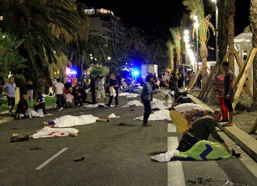 Photograph of the street in Nice where pedestrians were killed an injured by terrorists when they ran down innocent people, the photograph shows bodies scattered in the street covered with white sheets while first responders talk to bystanders & other wounded