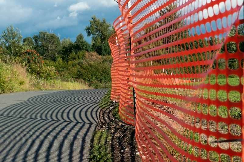 A photo showing the standard, orange, perforated, plastic landscape or construction fencing