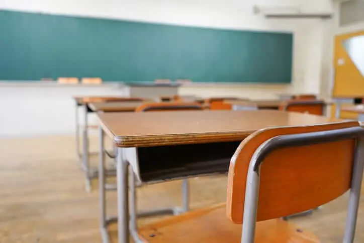 School classroom with blackboard and students desks & chairs