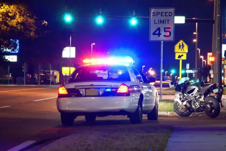 Police traffic stop at night with motorcycle pulled over