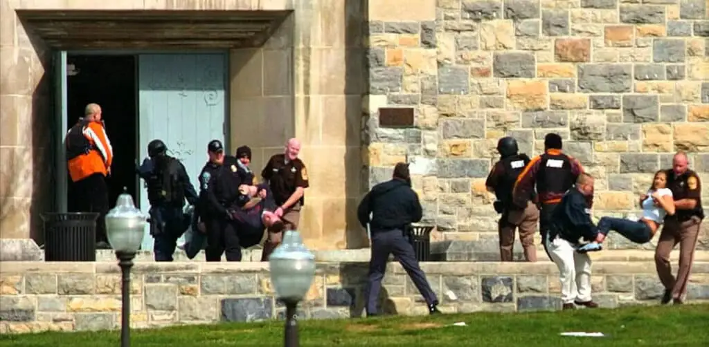 Law Enforcement officers carry wounded students out of Virginia Tech after a 2007 MCI shooting killing 32 and wounding 17 more