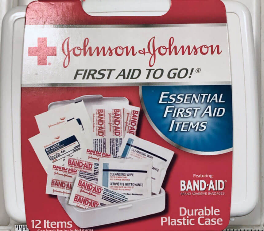 An anemic portable first aid kit containing half a dozen bandaids, two cleaning wipes, and two 2x2 gauze pads
