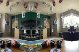 A nerf pistol lays on a table while paper ninjas buoyed by balloons gather for their attack