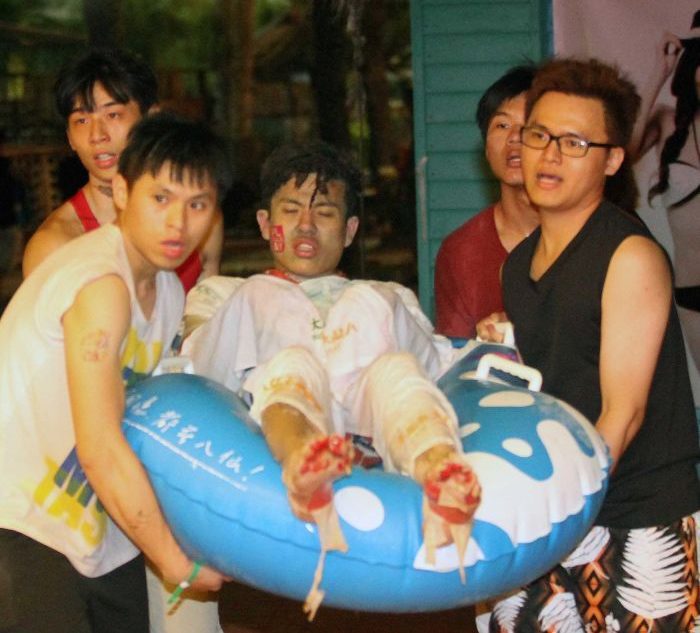 A photo of a man with full thickness burns being carried by bystanders on an inflatable toy after a burn MCI at a waterpark