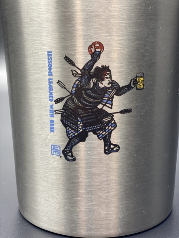 A closeup of the Samurai logo, festooned for Oktoberfest in Bavarian Blue & White, holding a pretzel overhead and a beer in his left hand