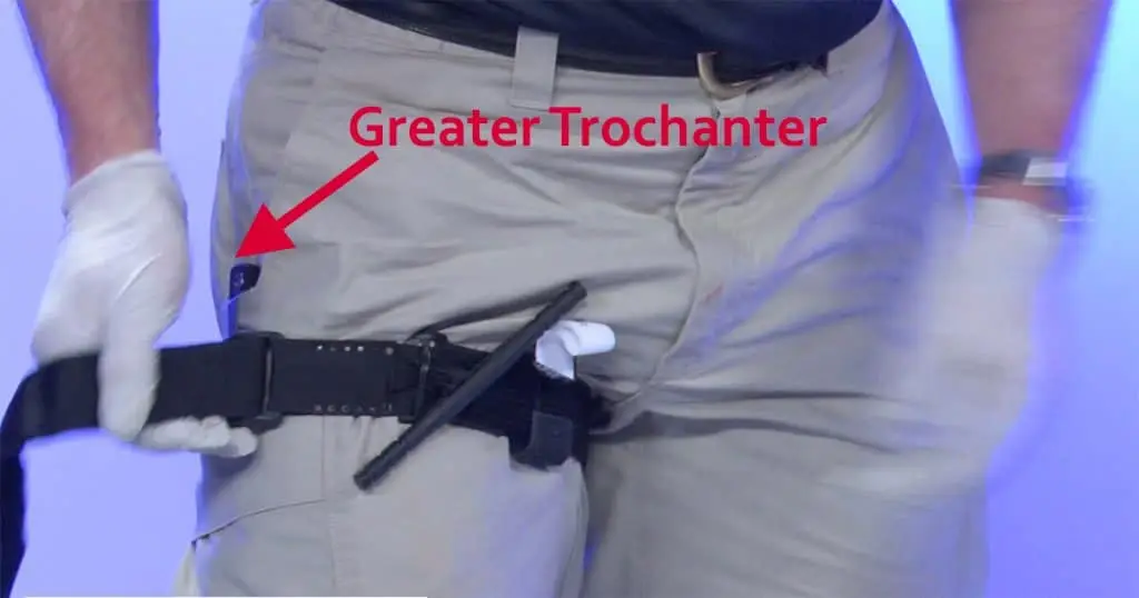 A tourniquet being placed high and tight pointing out the anatomical landmark of greater trochanter