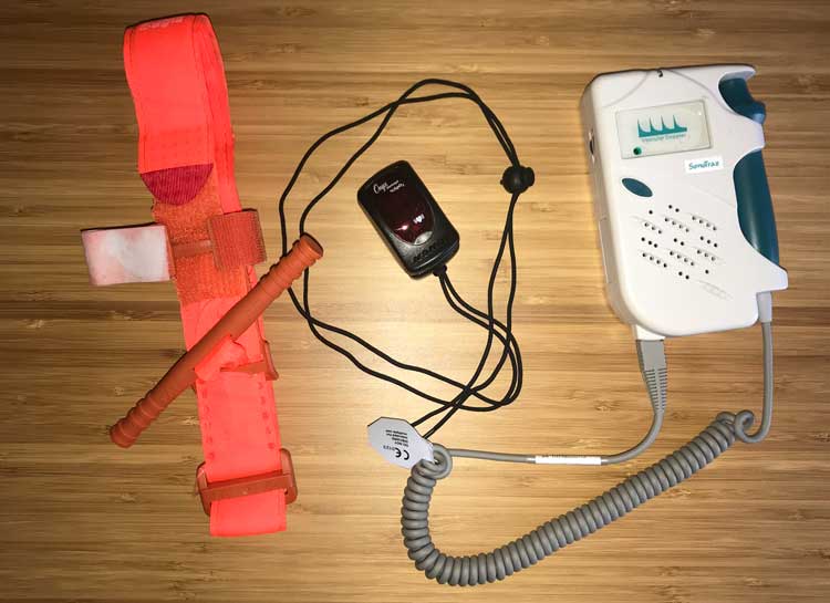 A CAT tourniquet, Nonin Pulse Ox, and Doppler displayed on a table