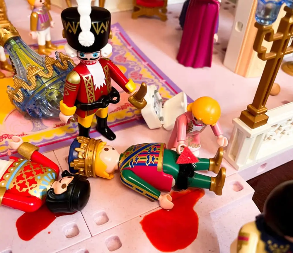 A photograph with Playmobil figures down and wounded with injuries suffered during an attack. A Playmobil sized CAT tourniquet is placed on the King in an effort to stop his massive hemorrhage