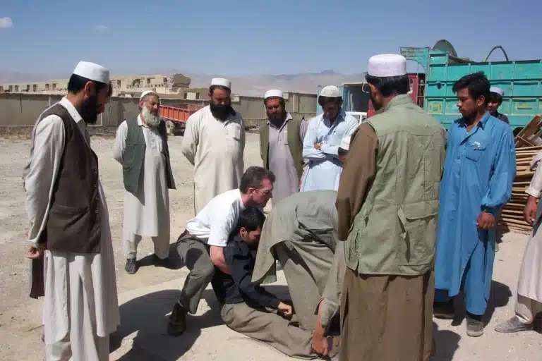 Dr. Shertz trains security drivers in Afghanistan, teaching them to properly lift a casualty in this photo
