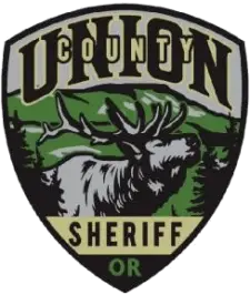 Union County Oregon Sheriff's patch with a moose in the center surrounded by a green mountain and fir trees