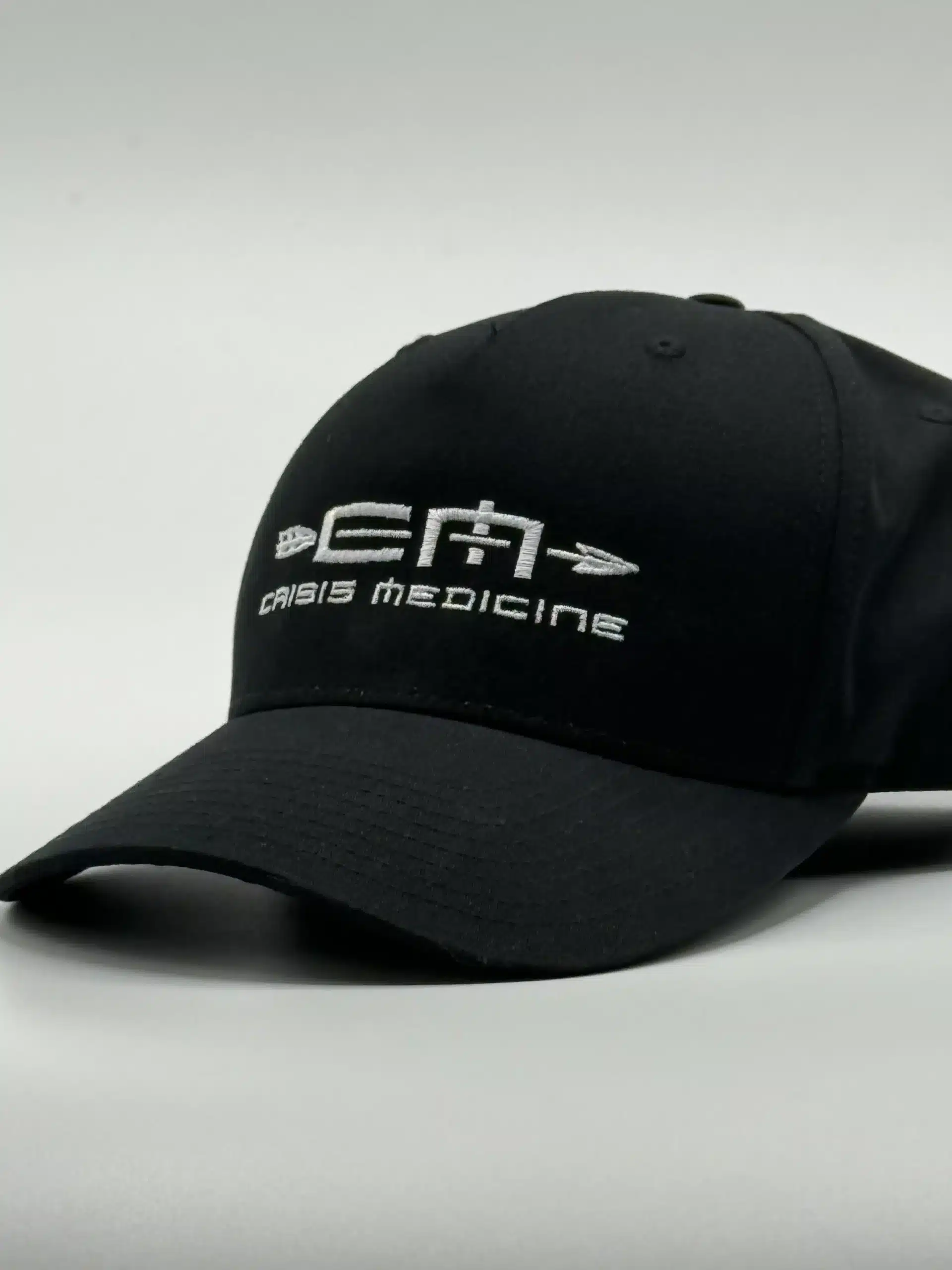Crisis Medicine Hat 3_4 ¾ view of the Crisis Medicine logo'd hat, solid black with the logo embroidered in white