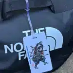 The Crisis Medicine Luggage Tag hanging on a North Face deployment bag