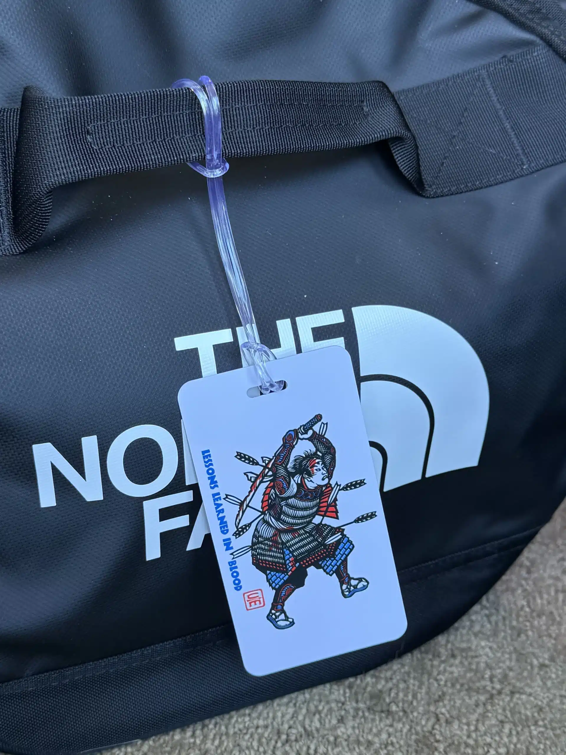 The Crisis Medicine Luggage Tag hanging on a North Face deployment bag